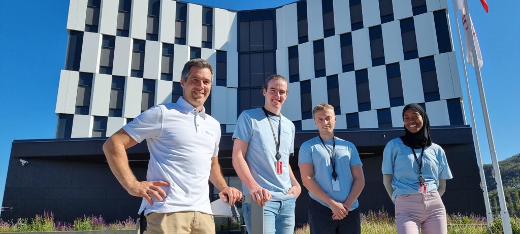 Picture of our employee Frode Eldevik together with three summer students who had a summer internship with us in the summer of 2023. The picture was taken outside Equnior's building in Harstad, where we have our main office.